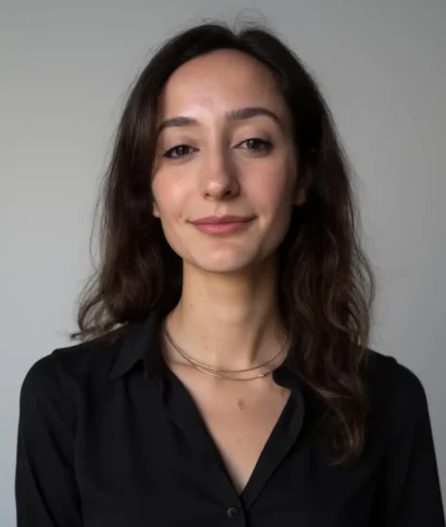 Professional woman with long dark hair wearing a black shirt, representing Ani, the website developer at Adonis Designs, known for her coding expertise and creative design skills.